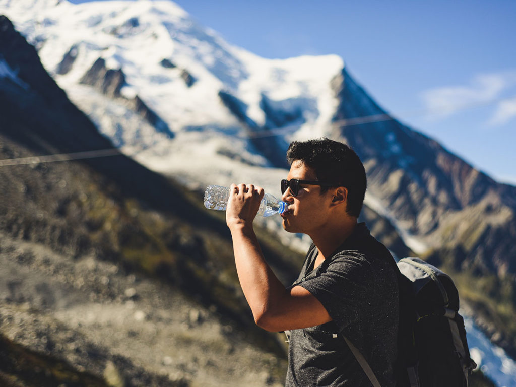 Homem bebendo água nas montanhas